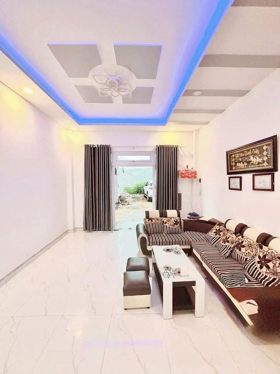 Thiết kế phòng khách nhà phố hiện đại với nội thất tối ưu, trần giật cấp đèn LED, sofa cao cấp. Thi công chuẩn đẹp bởi Nội Thất Tuấn Linh – giá tốt 2025.